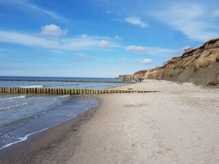 Fototapeta na wymiar Langer Sandstrand die Küste entlang am Meer