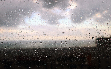 rain drops on window and storm clouds over the sea