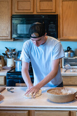 A young man kneads dough in preparation for a fresh batch of homemade pretzels.