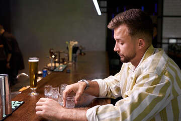 people, loneliness, alcohol concept. sad single young man drinking alcohol at bar or pub. feel depressed himself