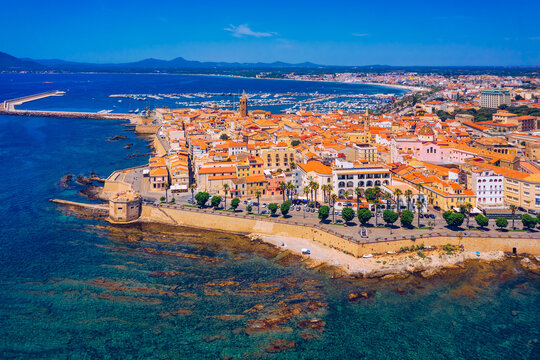 Aerial view over Alghero old town, cityscape Alghero view on a beautiful day with harbor and open sea in view. Alghero, Italy. Panoramic aerial view of Alghero, Sardinia, Italy.