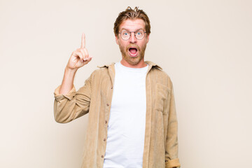 blonde adult caucasic man feeling like a happy and excited genius after realizing an idea,...