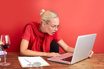 disgruntled woman look at laptop, dissatisfied with result on work. angry female feel herself unhappy, isolated red background
