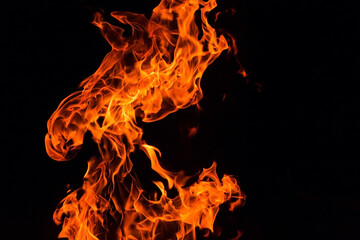 Bright orange red Fire flame against black background, abstract texture