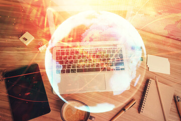 Business theme hologram drawings over computer on the desktop background. Top view. Multi exposure. Concept of international connections.