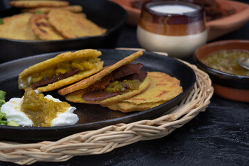 Vegan Mexican gorditas along with  fried seitan pieces , chile verde in traditional Mexican bowls