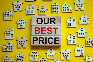 Wooden blocks form the words 'our best price', miniature wooden houses. Beautiful yellow background, copy space. Business concept.