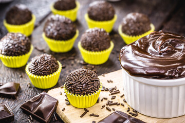 Brazilian chocolate truffle bonbon brigadeiro on wooden table. Sweet typical of children's parties