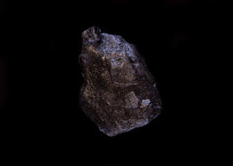 .super macro shot single crystal black hawaiian salt very close on black background isolated