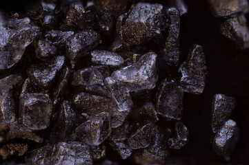 .super macro shot many crystals black hawaiian salt very close on black food background isolated