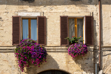 Fototapeta na wymiar Italian Window with Wooden Shutters in a brick wall