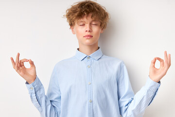 teenager caucasian boy in shirt relax and doing meditation gesture with fingers. yoga concept