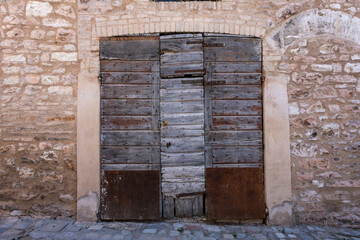 Classic old wooden door with bronze handles in Lucca, italy