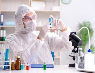 Young chemist student working in lab on chemicals