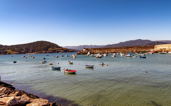 VIew of colorful boats in the serene harbor of Puerto de Espasante, a village on the coast of the Cantabran sea in the Galicia region of Spain.