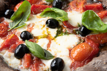 Pizza nera ai sette cereali con mozzarella, pomodorini, olive e basilico, Cucina Italiana