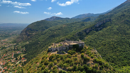 Aerial drone photo of iconic medieval byzantine uphill castle of Mystras with great scenic view to town of Mystras and Monasteries, Sparta, Peloponnese, Greece