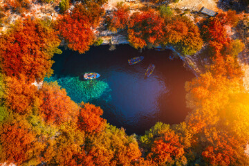 Fototapeta na wymiar Melissani Cave with autumn colors. Famous Melissani lake on Kefalonia island, Karavomylos, Greece. On top of Melissani Cave (Melissani Lake) in Karavomylos village in Kefalonia island , Greece.