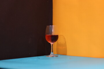 Red wine poured in wine glass and other glasses on a colourful table. Different glasses of wine with colourful background