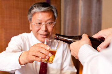 お酌してもらうビジネスマン