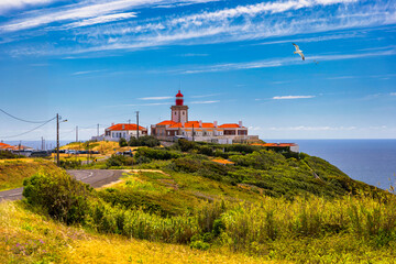 Fototapeta na wymiar The lighthouse in Cabo da Roca. Cliffs and rocks on the Atlantic ocean coast in Sintra in a beautiful summer day, Portugal. Cabo da Roca, Portugal. Lighthouse and cliffs over Atlantic Ocean.