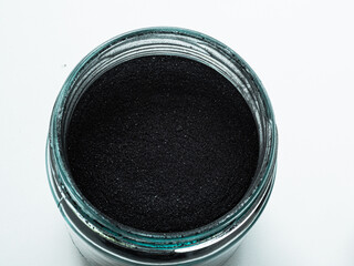 Activated carbon powder for cosmetic face mask in one glass jars, top view on white background