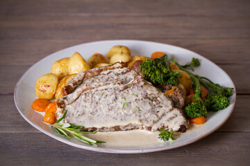 Roast beef steak fillets with creamy Gorgonzola cheese dressing and vegetables on plate. Horizontal photo