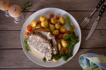 Roast beef steak fillets with creamy Gorgonzola cheese dressing and vegetables on plate. Overhead, flat lay photo