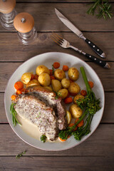 Roast beef steak fillets with creamy Gorgonzola cheese dressing and vegetables on plate. Overhead, flat lay photo