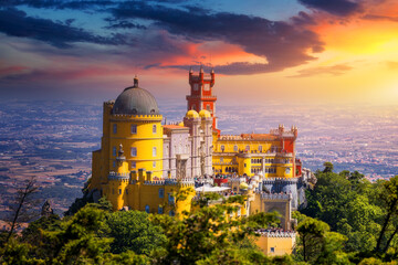 Famous historic Pena palace part of cultural site of Sintra against sunset sky in Portugal. Panoramic View Of Pena Palace, Sintra, Portugal. Pena National Palace at sunset, Sintra, Portugal. - obrazy, fototapety, plakaty