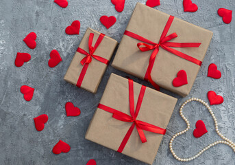 Romantic background with gifts tied with a red ribbon and red hearts