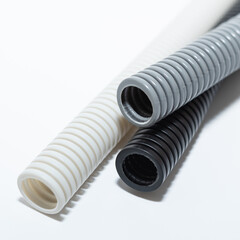 PVC flexible electrical conduit isolated on white background. Plastic curvilinear hoses. Colored...