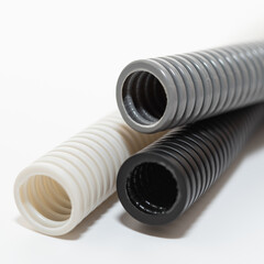 PVC flexible electrical conduit isolated on white background. Plastic curvilinear hoses. Colored corrugated pipe for installation of electrical cable