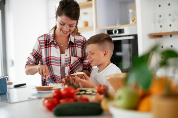 Mother and son making breakfast. Mother and son eating sandwich in kitchen...