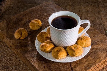 Rosquillas, rosquitas, donas para desayuno con taza de café en mesa de madera, desde Cajamarca Perú.