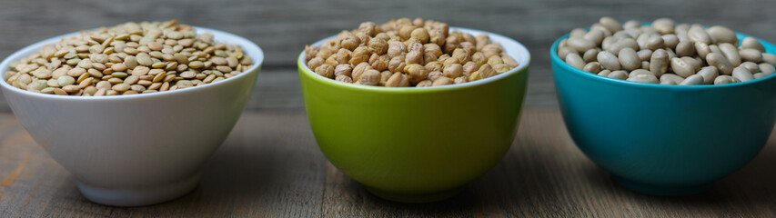 garbanzos, porotos y lentejas en pocillos sobre madera 