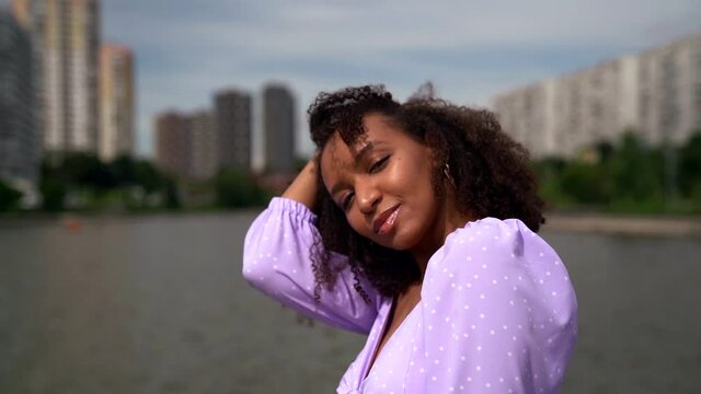 attractive black woman is dancing outdoors at city landscape at summer vacation, portrait shot