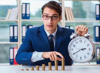 Businessman with stacks of coins in the office