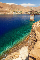 Megalo Livadi, a picturesque bay in Serifos island, Cyclades, Greece. There is a metal bridge where mines were loaded from the local mine. - obrazy, fototapety, plakaty