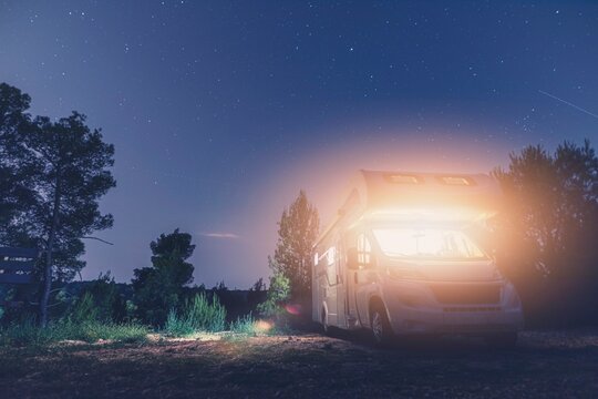a camper van parked in the woods at night - Freelancer nomad tele working inside camper van. Serene 