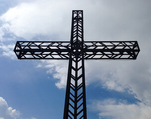 cross on a mountain peak at the garda lake, city of Arco, northern italy