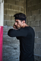 Obraz premium A handsome man in a black shirt punching a boxing bag