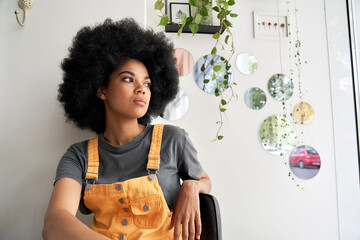 Young thoughtful pensive stylish African American gen z female hipster woman with afro hair looking...