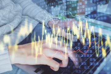 Double exposure of woman hands typing on computer and forex chart hologram drawing. Stock market invest concept.