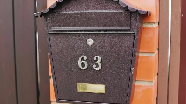 Close-up of a mailbox hanging on the wall near a private house.