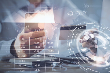 Double exposure of man hands holding a credit card and Forex graph drawing. Stock trading and digital fintech in Internet E-commerce concept.