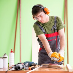 Young man carpenter working in workshop