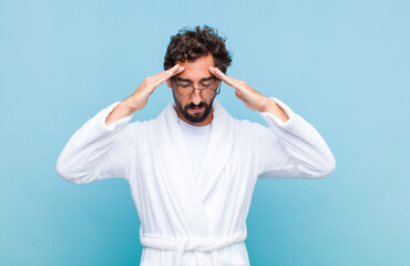 young bearded man wearing a bath robe looking concentrated, thoughtful and inspired, brainstorming...
