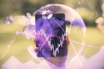 Double exposure of forex chart sketch hologram and woman holding and using a mobile device. Financial market concept.