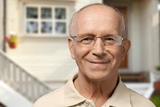 Old senior man standing on blur house background